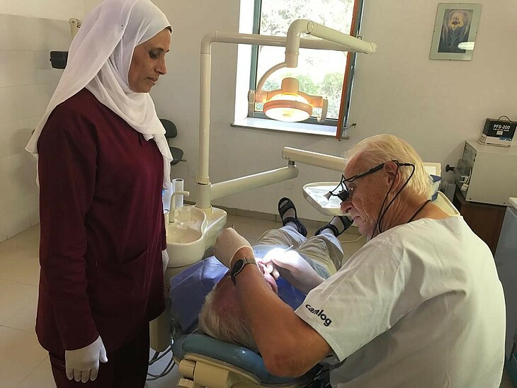 Zahnarzt Dr. Theo Römer bei der Behandlung eines Patienten