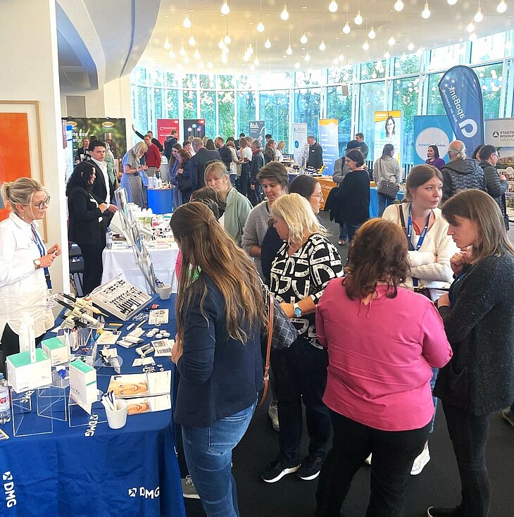 Foto vom DMG Stand mit Besuchern auf dem Fränkischen Zahnärztetag