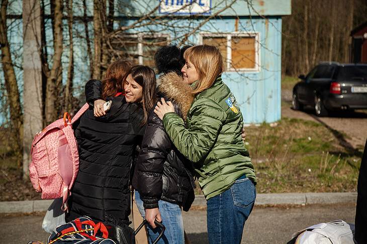 Gerettete ukrainische Kinde umarmen ihre Angehörigen