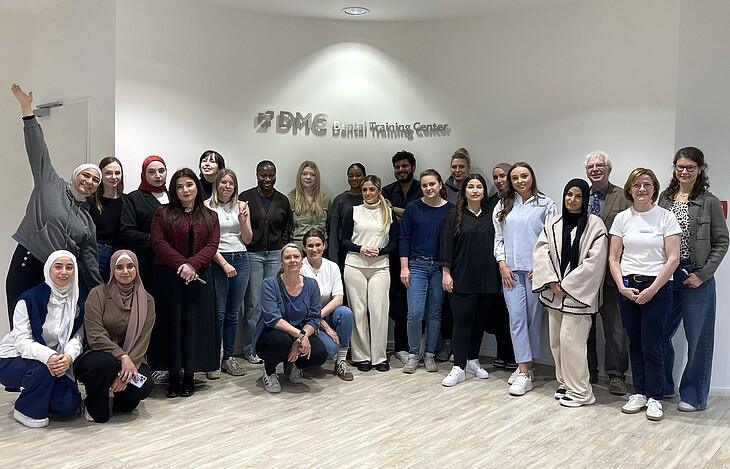 Eine große Gruppe von ZFA-Azubis vor dem DMG Logo im DMG Dental Training Center